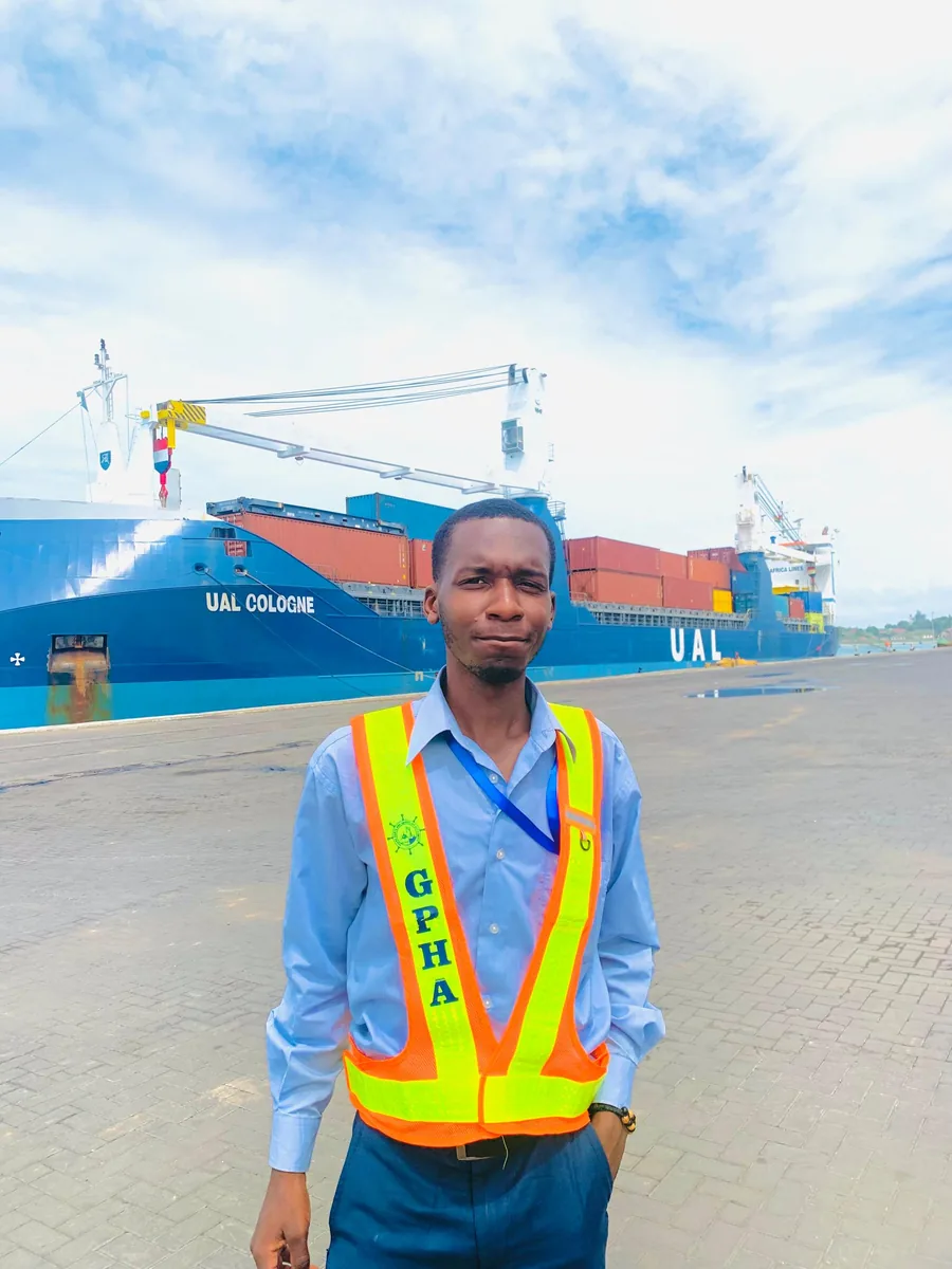 Leonard at Takoradi port with cargo ships behind him